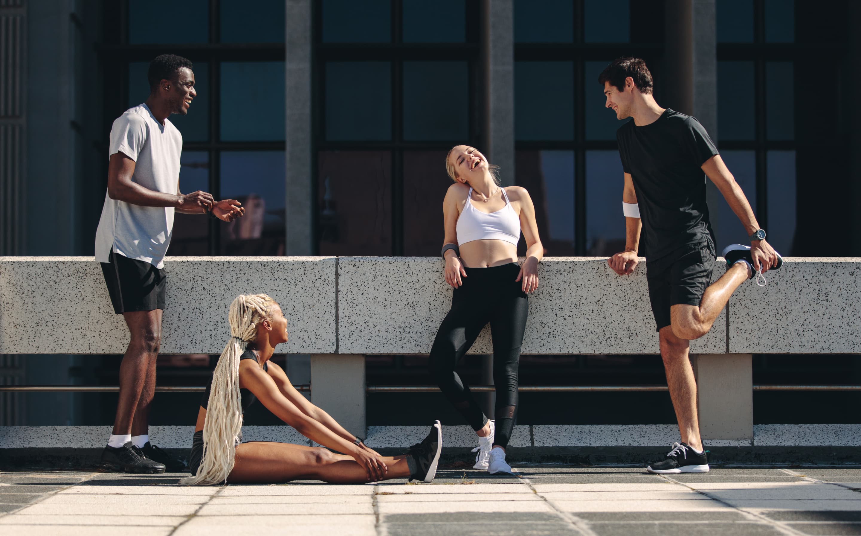 Ragazzi che parlano mentre fanno stretching in abiti sportivi